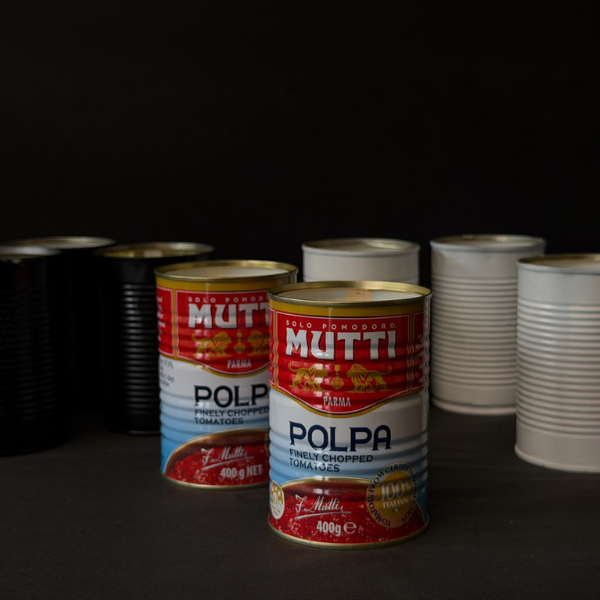 Collection of recycled Mutti Polpa tins that've been turned into candles on a dark surface. Designed for outdoors (although can be indoors too) these Hand made candles are fragranced with Citronella and Lemongrass with a touch of Lavender. Recycled tins are filled with soy/plant based wax blended with pure essential oils, intended as a mild deterrent for annoying bugs. Available at LOVINLIFE Co Byron Bay.