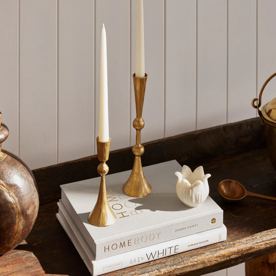Enchant Brass Candle Stands holding candles pictured on top of books on a sideboard - available at LOVINLIFE Co Byron Bay for all your gifts, candles and interior decorating needs