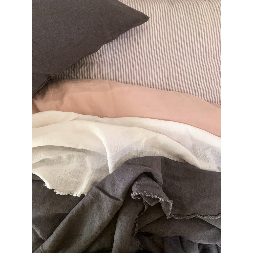 French flax linen sheets, prewashed and softened to sit gently against your skin – A selection of Charcoal, pink, white and Pinstripe French linen bed sheet pictured - available at LOVINLIFE Co Byron Bay for all your gifts, candles and interior decorating needs