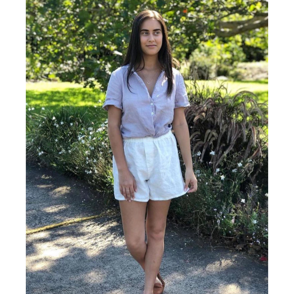 French flax linen unisex boxer shorts, loose, comfy and playful for men and women of all shapes and sizes - Available in 5 colours: White, Pinstripe, Natural, Navy & Charcoal – White boxer shorts pictured on woman walking along a footpath - available at LOVINLIFE Co Byron Bay for all your gifts, candles and interior decorating needs