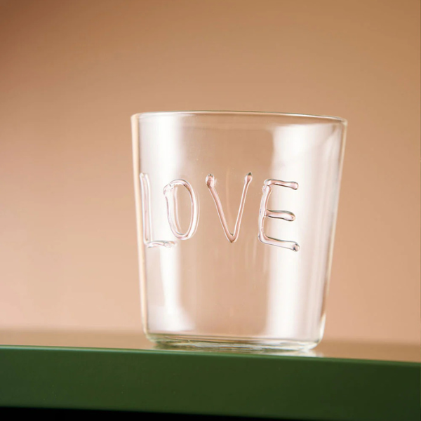 Clear glass tumbler with 'LOVE' engraving on a beige background. Part of the Robert Gordon Collection stocked at LOVINLIFE Co Byron Bay for all your gifts, candles, homewares and interior decorating needs