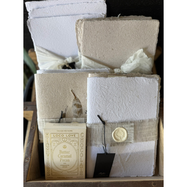Display of Hand Pressed Paper Products and a box of Loco Love Butter Caramel pecan Chocolates. Stocked at LOVINLIFE Co Byron Bay for all your gifts, candles and interior decorating needs