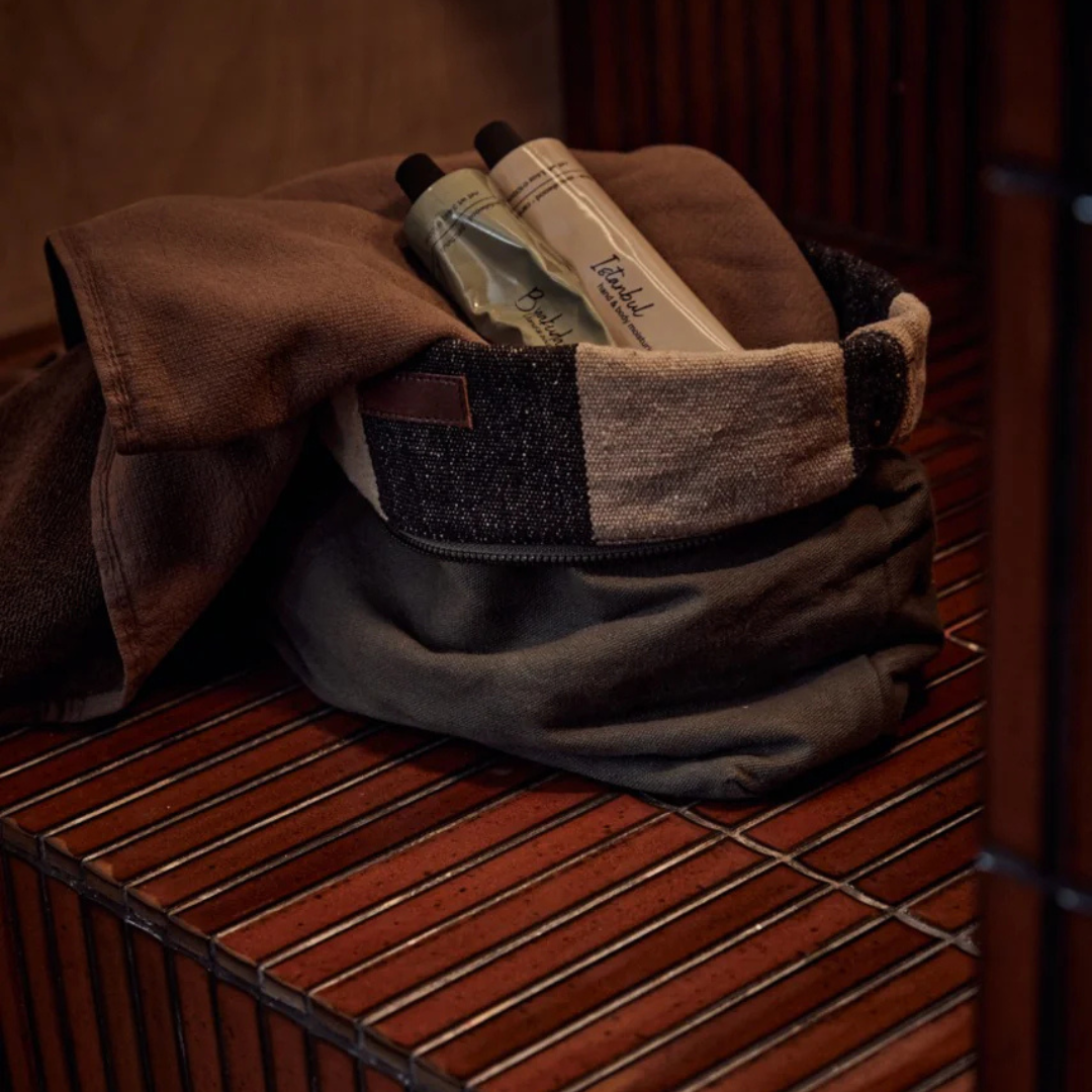 Hand & Body Moisturiser by Saarde - Byakudan and Istanbul pictured in a toiletry bag on a red tiled bench - Stocked at LOVINLIFE Co Byron Bay for all your gifts, candles and interior decorating needs