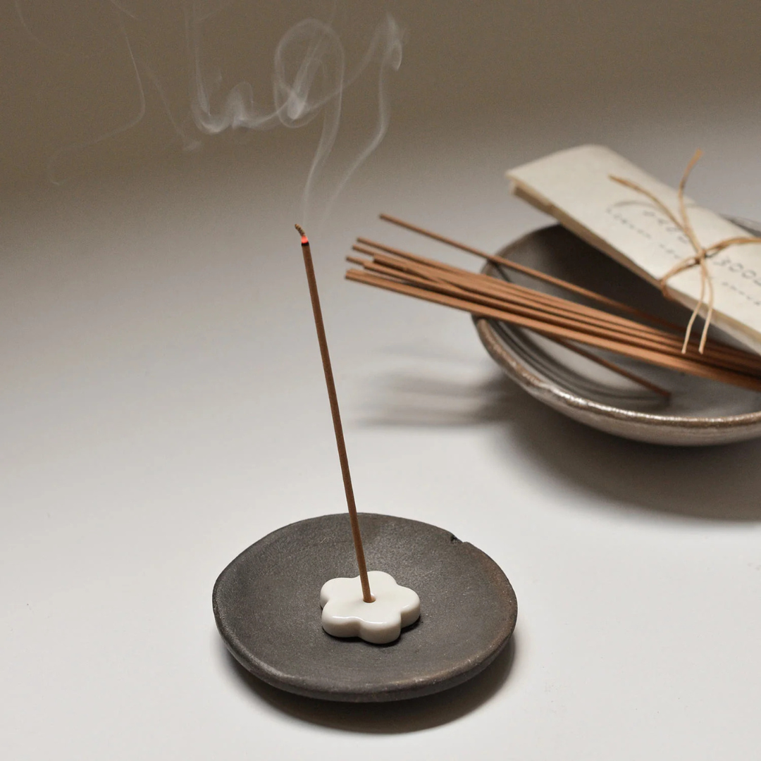 Black Clay Incense Plate - Handcrafted smudging bowl or plate pictured with smoking incense stick resting on on top - Stocked at LOVINLIFE Co Byron Bay for all your gifts, candles and interior decorating needs