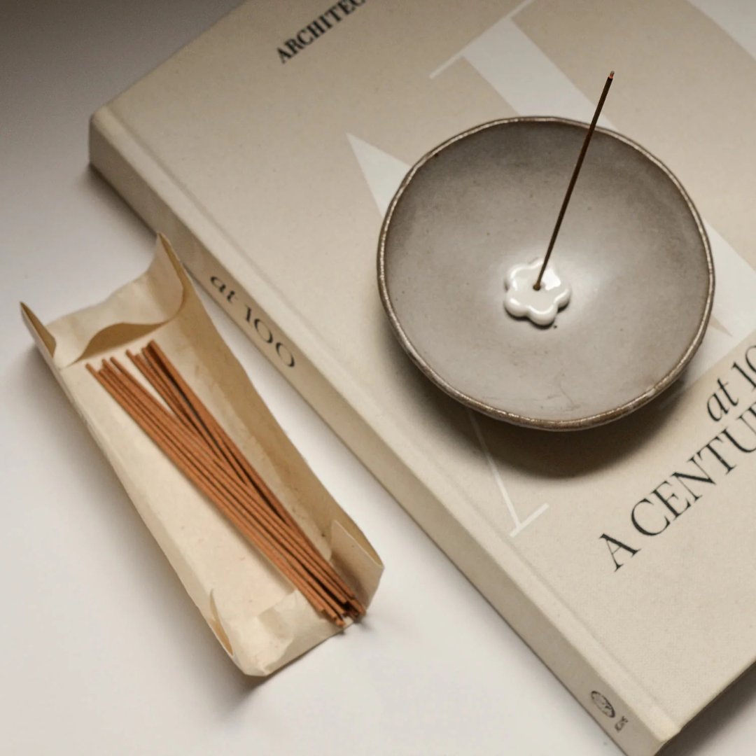 Incense Set - picture of an incense stick standing in the holder, placed in a clay smudging bowl on top of a book - Stocked at LOVINLIFE Co Byron Bay for all your gifts, candles and interior decorating needs