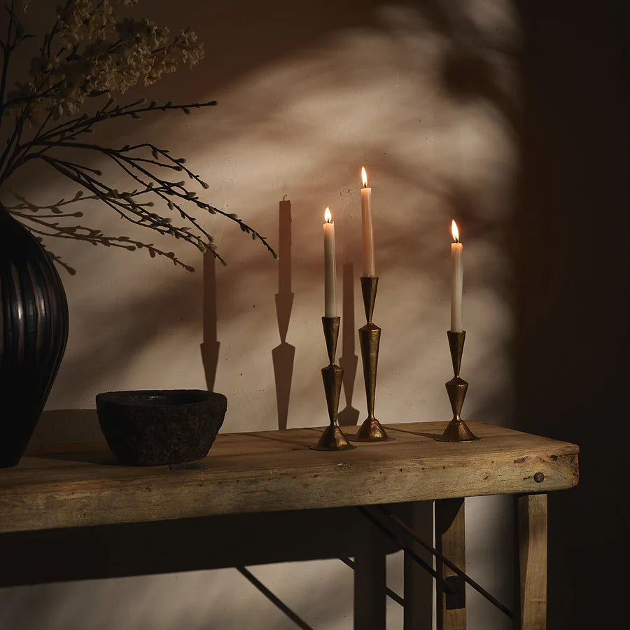 Iris Brass Candle Stands x 3 holding white candles on a wooden hall table - available at LOVINLIFE Co Byron Bay for all your gifts, candles and interior decorating needs
