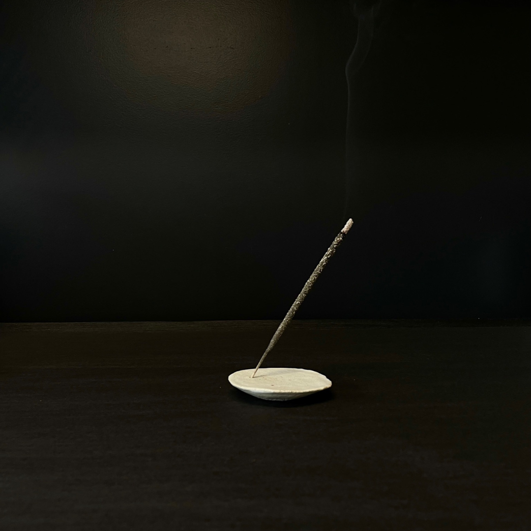 Lovinlife Co ByronBay – handmade Ceramic Half Moon Incense Holder with a flat surface these delicate pieces are effortlessly simple and appear to be floating – pictured from side holding smoking incense stick - available at LOVINLIFE Co Byron Bay for all your gifts, candles and interior decorating needs