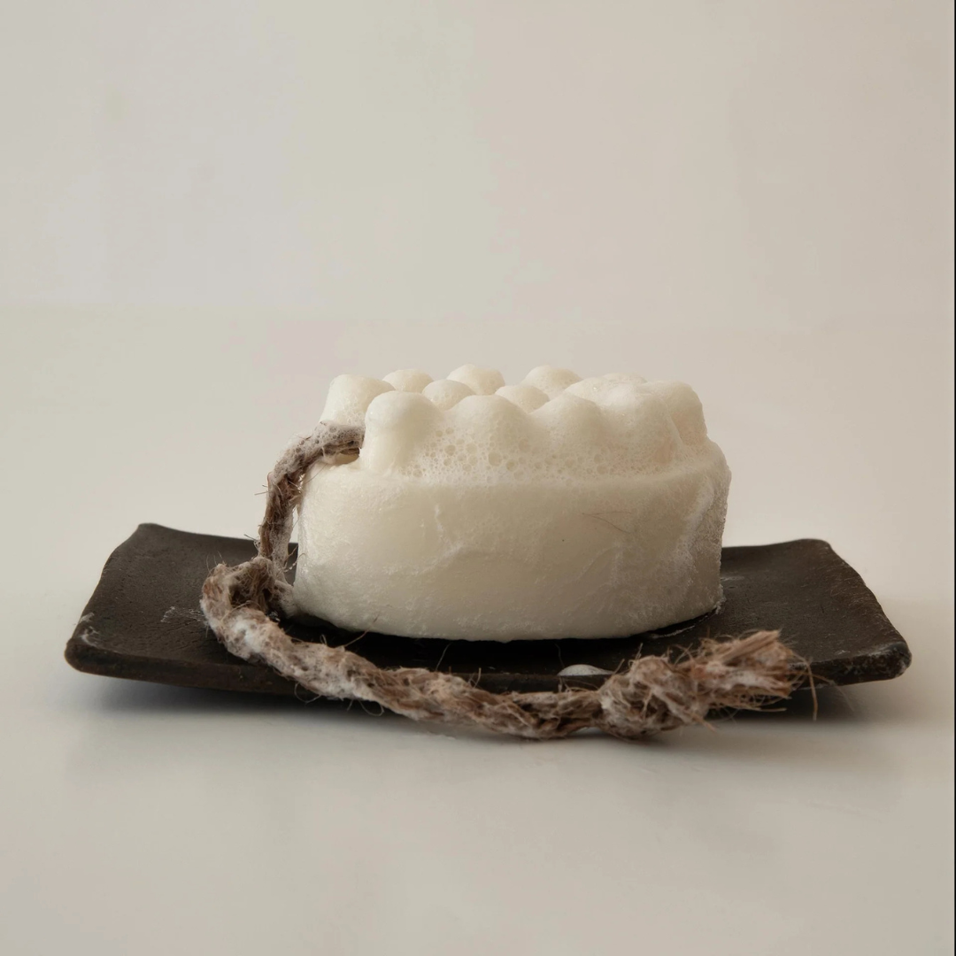 Palo Santo Bar Soap - white - picture of the soap on a rope resting on a black clay soap dish with suds all over - Stocked at LOVINLIFE Co Byron Bay for all your gifts, candles and interior decorating needs