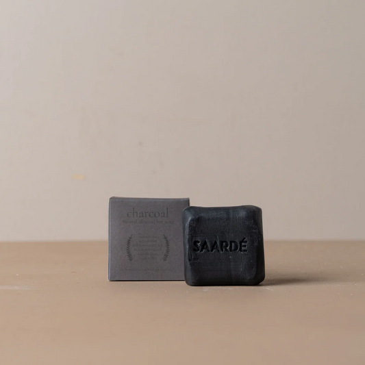 Lovinlife Co ByronBay – Saarde Charcoal Olive Oil Bar Soap – Activated Charcoal for deep cleaning, gentle exfoliation, absorbing excess oil - unscented – soap bar pictured on bench next to box - available at LOVINLIFE Co Byron Bay for all your gifts, candles and interior decorating needs