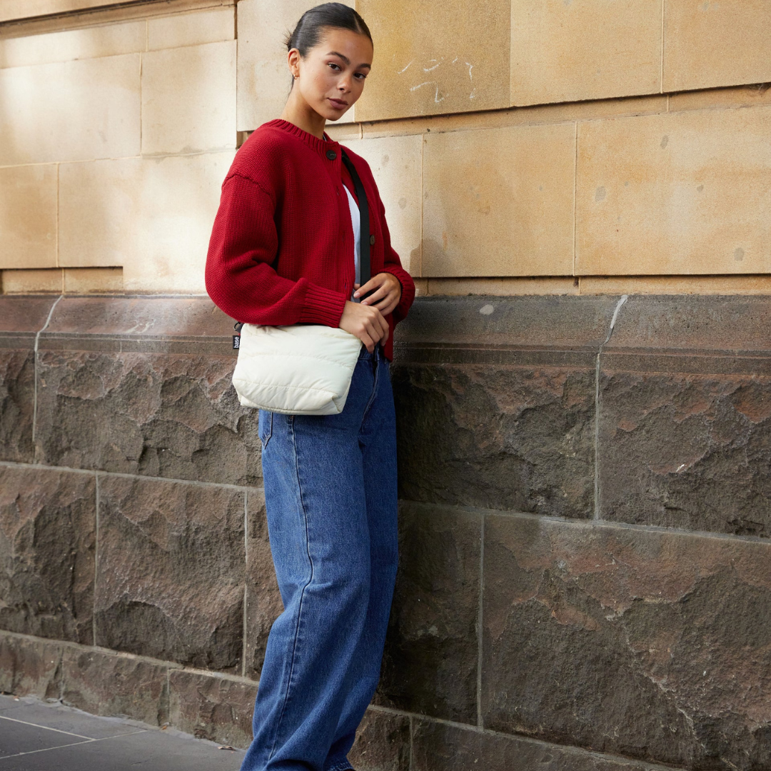 Stash Base Crossbody Bag - an everyday crossbody bag in soft, cloud-like fabric - ecru white bag pictured being worn across the body and resting on the hip - Stocked at LOVINLIFE Co Byron Bay for all your gifts, candles and interior decorating needs