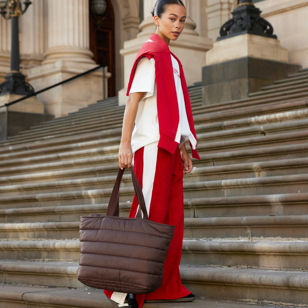 Take it Base Bag - A large soft-as-a-cloud shoulder bag for days on the go or weekends away - Chocolate bag pictured being carried by the handle - Stocked at LOVINLIFE Co Byron Bay for all your gifts, candles and interior decorating needs