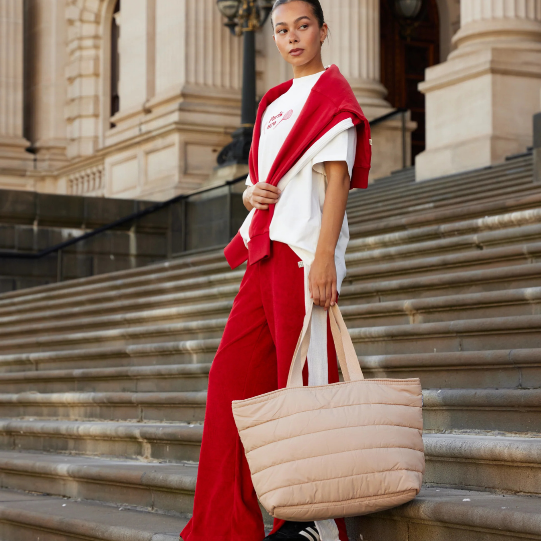 Take it Base Bag - A large soft-as-a-cloud shoulder bag for days on the go or weekends away - Sand bag pictured being carried by the handles - Stocked at LOVINLIFE Co Byron Bay for all your gifts, candles and interior decorating needs