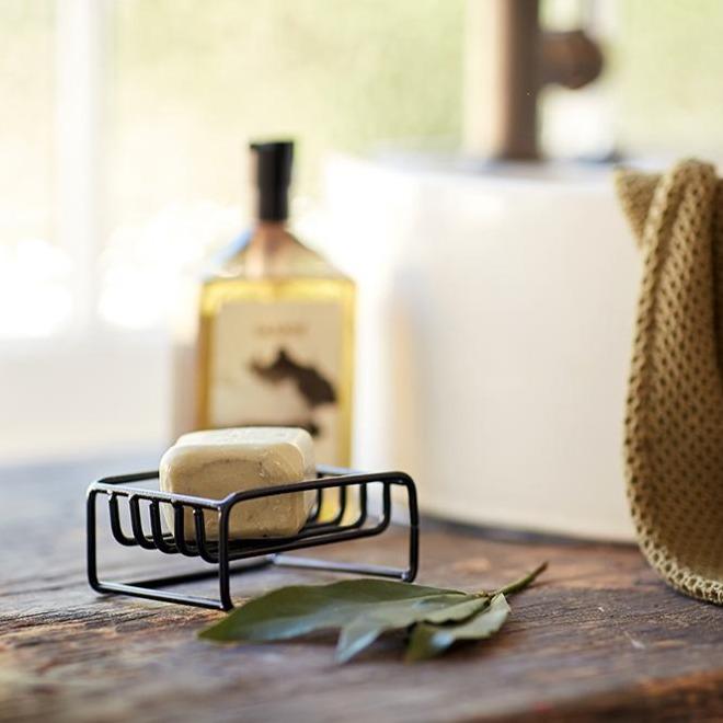 Lovinlife Co ByronBay – Saarde Clay Olive Oil Bar Soap – draws out impurities from blocked pores, beneficial for acne prone or oily skin - unscented – soap bar pictured in black metal soap holder on wooden bench - available at LOVINLIFE Co Byron Bay for all your gifts, candles and interior decorating needs