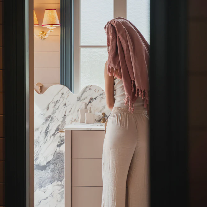 Saarde Room Spray bottle on marble bathroom vanity with girl and towel wrapped hair - Stocked at LOVINLIFE Co Byron Bay for all your gifts, candles and interior decorating needs