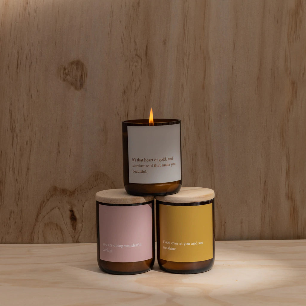 Commonfolk Candles from the heartfelt collection - amber glass jar with wood lids, stacked on wooden backdrop with top candle lit - Stocked at LOVINLIFE Co Byron Bay for all your gifts, candles and interior decorating needs