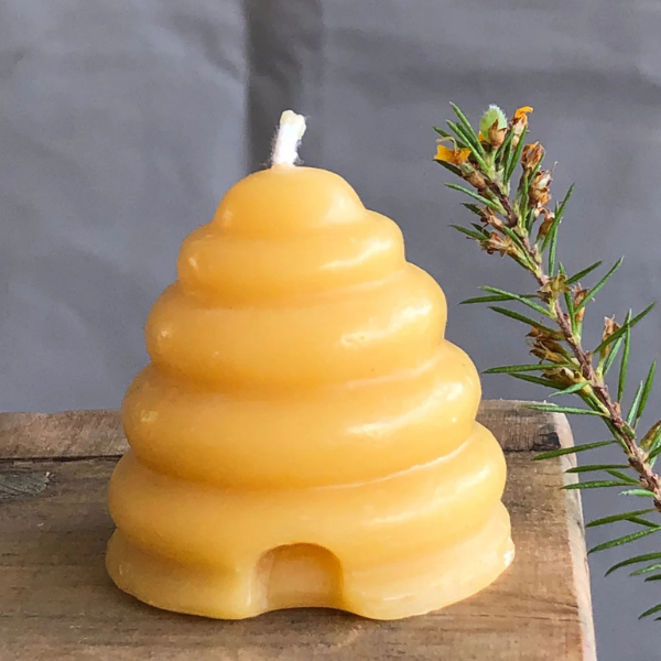 Pure beeswax candle with pure cotton wick shaped like a beehive on a wooden surface with a natural background. Stocked at LOVINLIFE Co Byron Bay for all your gifts, candles and interior decorating needs