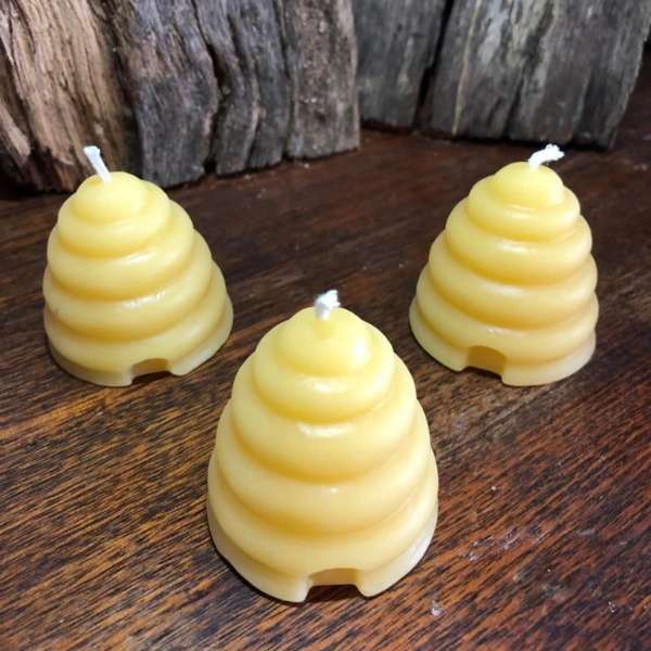 Three beehive-shaped candles made with 100% pure beeswax and 100% cotton wicks on a wooden surface with a rustic background. Stocked at LOVINLIFE Co Byron Bay for all your gifts, candles and interior decorating needs