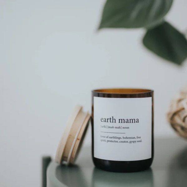 Candle labelled 'earth mama' with a wooden lid on a light surface. These Dictionary Meaning Candles are one of our most loved products. We have spent an abundance of time, curating our own meanings of the words to help you feel connected, to help you tell someone how you feel in a unique way. Available at LOVINLIFE Co Byron Bay