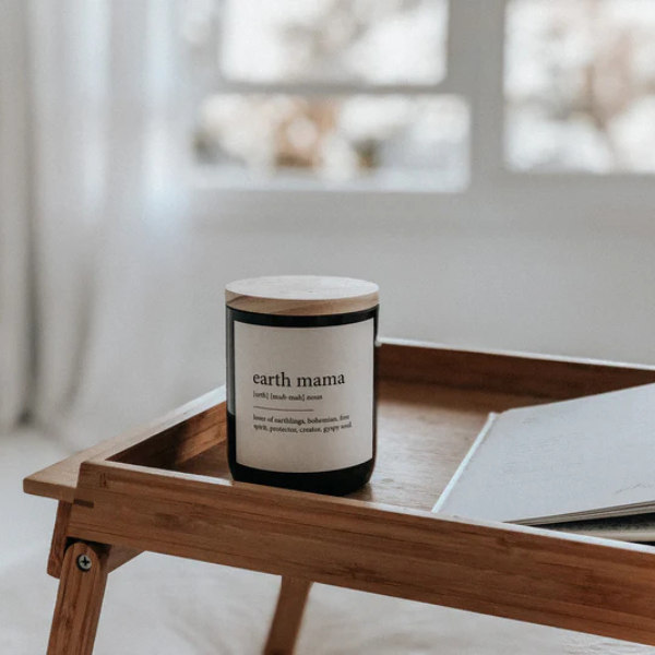 Candle labelled 'earth mama' on a wooden tray with a blurred indoor background. These Dictionary Meaning Candles are one of our most loved products. We have spent an abundance of time, curating our own meanings of the words to help you feel connected, to help you tell someone how you feel in a unique way. Available at LOVINLIFE Co Byron Bay