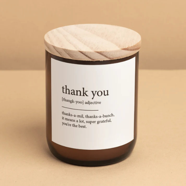 Candle with a wooden lid and 'thank you' label on a beige background. These Dictionary Meaning Candles are one of our most loved products. We have spent an abundance of time, curating our own meanings of the words to help you feel connected, to help you tell someone how you feel in a unique way. Available at LOVINLIFE Co Byron Bay