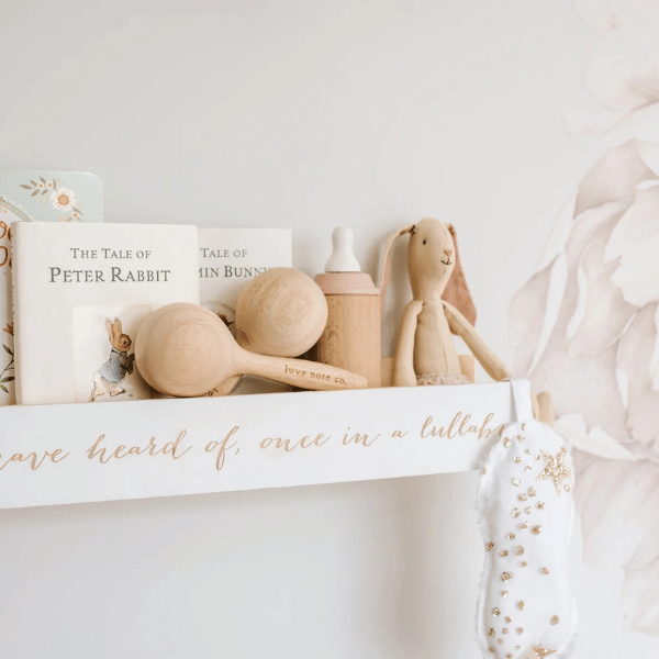 Set of Maracas made with FSC certified oak wood, sitting on a shelf with other toys and "the tale of Peter Rabbit" book. All  instruments by Love Note Co are handmade items, non-toxic, eco-friendly and sustainably sourced. Stocked at LOVINLIFE Co Byron Bay for all your gifts, candles and interior decorating needs