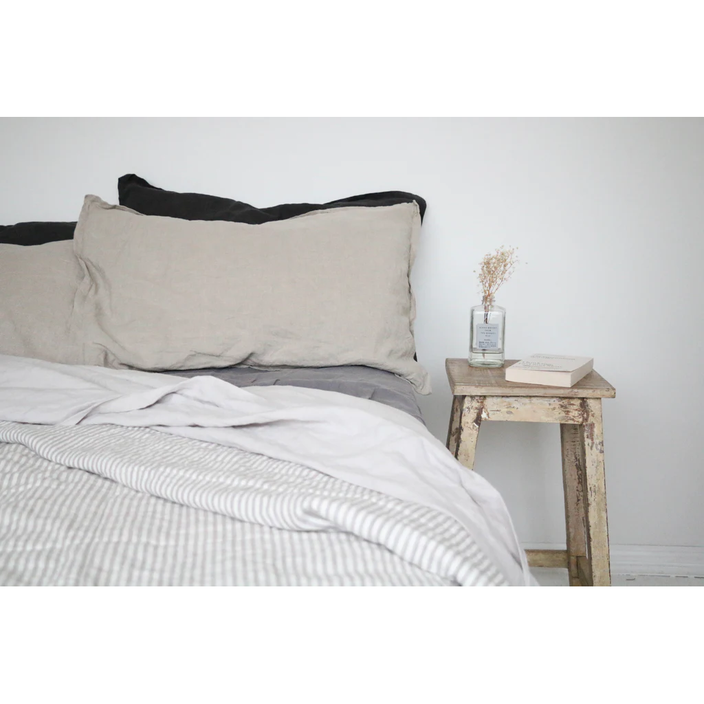 French flax linen sheets, prewashed and softened to sit gently against your skin – pictured made on a bed with pinstripe, natural and charcoal coloured French linen bed sheets - available at LOVINLIFE Co Byron Bay for all your gifts, candles and interior decorating needs