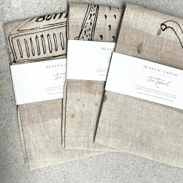 3 x French Linen Tea Towels pictured folded in their packaging bands. Designed in Australia, Heaven In Earth, available at LOVINLIFE Co Byron Bay