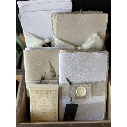 Display of Hand Pressed Paper Products and a box of Loco Love Butter Caramel pecan Chocolates. Stocked at LOVINLIFE Co Byron Bay for all your gifts, candles and interior decorating needs