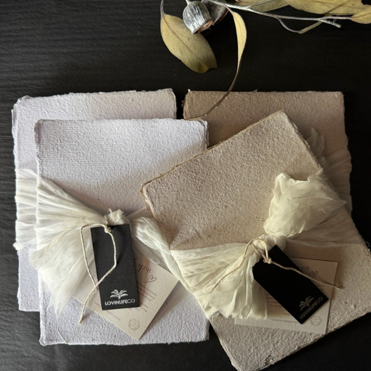 Flat lay of 2 x Bundles of Hand Pressed Paper A5 pages in white and natural with small flecks of grasses. Stocked at LOVINLIFE Co Byron Bay for all your gifts, candles and interior decorating needs 