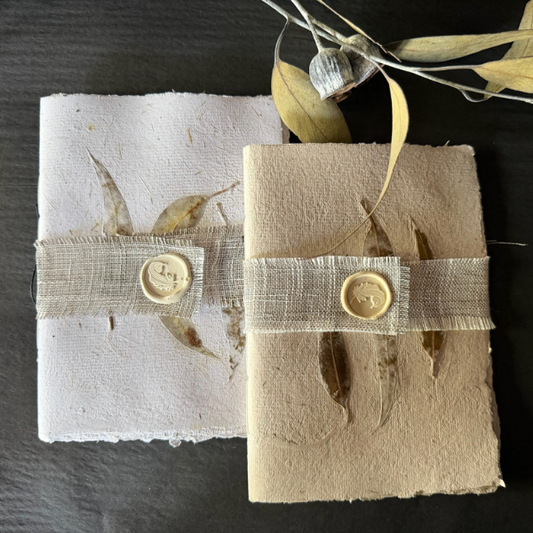 Flat lay of 2 x Hand Pressed Paper A5 Notebooks 20 page in white and natural, with the cover of each impressed with 3 x Australian Gum leaves. Stocked at LOVINLIFE Co Byron Bay for all your gifts, candles and interior decorating needs 