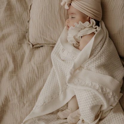 Baby wrapped in an organic cotton textured Knit Heirloom Baby Blanket in Cream. Stocked at LOVINLIFE Co Byron Bay for all your gifts, candles and interior decorating needs
