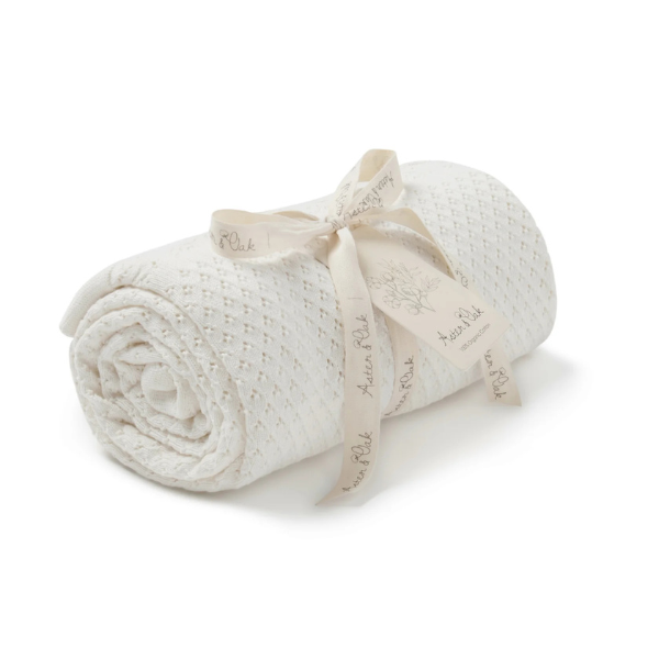 Rolled-up organic cotton textured Knit Heirloom Baby Blanket in Cream with a ribbon on a white background. Stocked at LOVINLIFE Co Byron Bay for all your gifts, candles and interior decorating needs