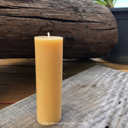Large pure beeswax mini pillar candle on a wooden surface, with a pure cotton wick. Stocked at LOVINLIFE Co Byron Bay for all your gifts, candles and interior decorating needs