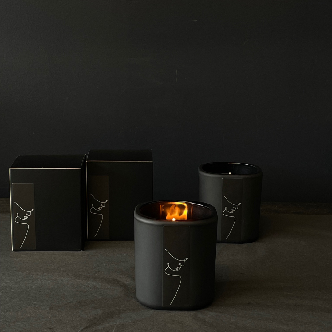 Lovinlife Co ByronBay - Signature Candle Range, also available for wholesale - Unisex Black Candle pictured alight with black boxes on black background - Red Apple, Black Pepper, Tobacco, Tonka Bean & Patchouli scent profile - available at LOVINLIFE Co Byron Bay for all your gifts, candles and interior decorating needs