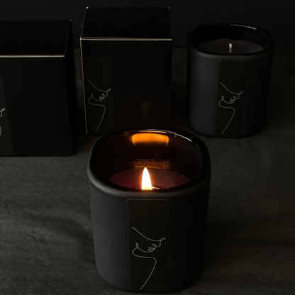 Lovinlife Co ByronBay - Signature Candle Range, also available for wholesale - Unisex Black Candle pictured alight with black boxes on black background - Red Apple, Black Pepper, Tobacco, Tonka Bean & Patchouli scent profile - available at LOVINLIFE Co Byron Bay for all your gifts, candles and interior decorating needs