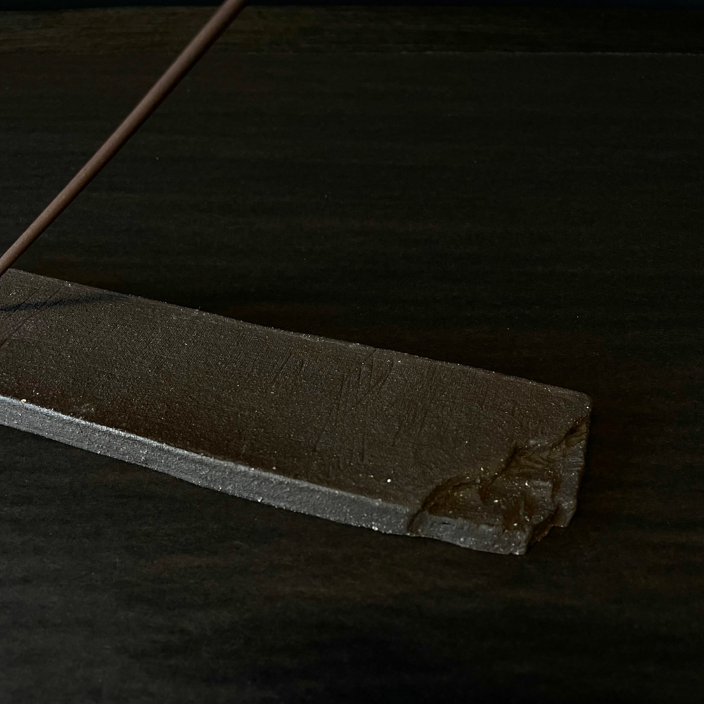 Lovinlife Co ByronBay - Handmade Signature Ceramics Range - Dark Matter Slab Series, matt black stone finish clay pieces - Incense Holder - Long Slab holding a smoking incense stick, close up to show raw clay edge detail - available at LOVINLIFE Co Byron Bay for all your gifts, candles and interior decorating needs