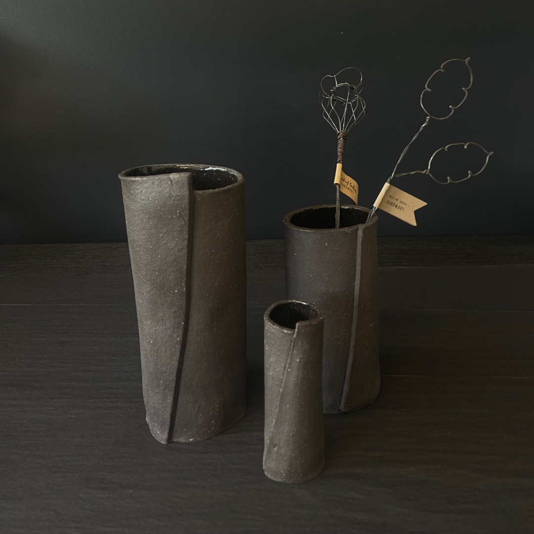 Lovinlife Co ByronBay - Handmade Signature Ceramics Range - Dark Matter Slab Series, matt black stone finish clay pieces - Slab Fold Vase 4 pictured next to two smaller size vases, one holding twisted wire decorations - available at LOVINLIFE Co Byron Bay for all your gifts, candles and interior decorating needs