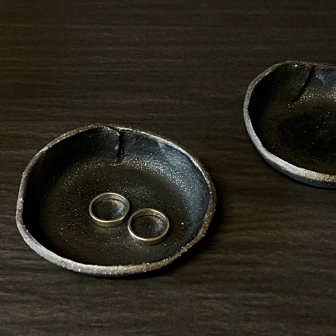 Lovinlife Co ByronBay - Handmade Signature Ceramics Range - Dark Matter Slab Series, matt black stone finish clay pieces - soft fold dishes pictured holding rings - available at LOVINLIFE Co Byron Bay for all your gifts, candles and interior decorating needs