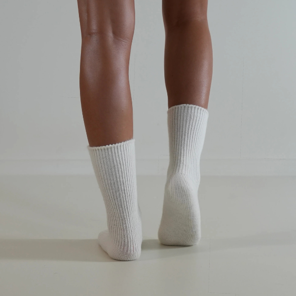Milk coloured socks on a person’s feet, back view, on a plain background. Luxe Cashmere Blend Socks by Number Thirty One made with a premium blend of cashmere and wool. Unisex & One size. Stocked at LOVINLIFE Co Byron Bay for all your gifts, candles and interior decorating needs