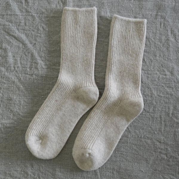 Pair of Natural coloured socks flat lay on a linen background. Luxe Cashmere Blend Socks by Number Thirty One made with a premium blend of cashmere and wool. Unisex & One size. Stocked at LOVINLIFE Co Byron Bay for all your gifts, candles and interior decorating needs