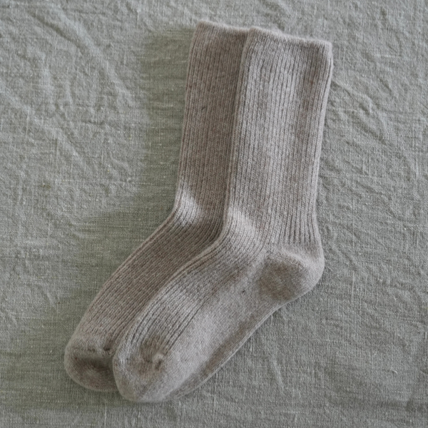 Pair of Taupe coloured socks flat lay on a linen background. Luxe Cashmere Blend Socks by Number Thirty One made with a premium blend of cashmere and wool. Unisex & One size. Stocked at LOVINLIFE Co Byron Bay for all your gifts, candles and interior decorating needs