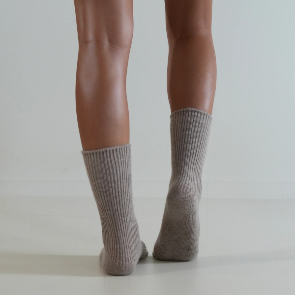 Taupe coloured socks on a person’s feet, back view, on a plain background. Luxe Cashmere Blend Socks by Number Thirty One made with a premium blend of cashmere and wool. Unisex & One size. Stocked at LOVINLIFE Co Byron Bay for all your gifts, candles and interior decorating needs