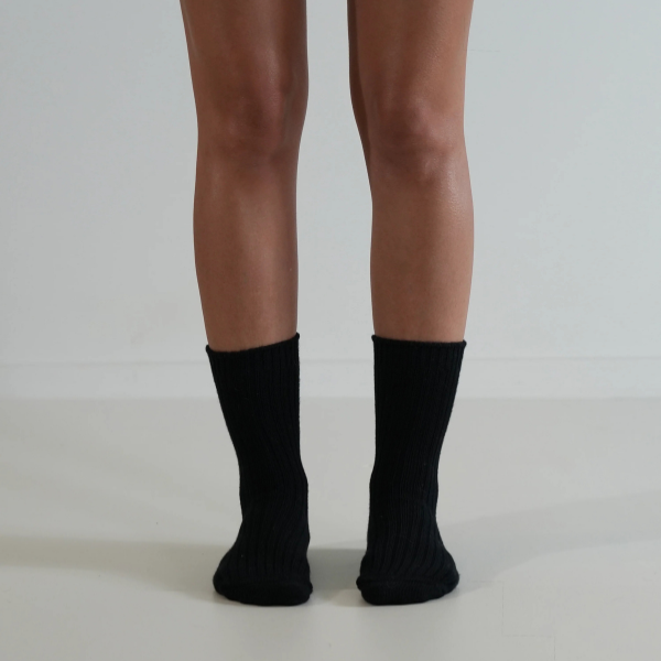 Black socks on a person’s feet, front view, on a plain background. Luxe Cotton Socks by Number Thirty One made with a soft cotton, wool, and spandex blend. Unisex & One size. Stocked at LOVINLIFE Co Byron Bay for all your gifts, candles and interior decorating needs
