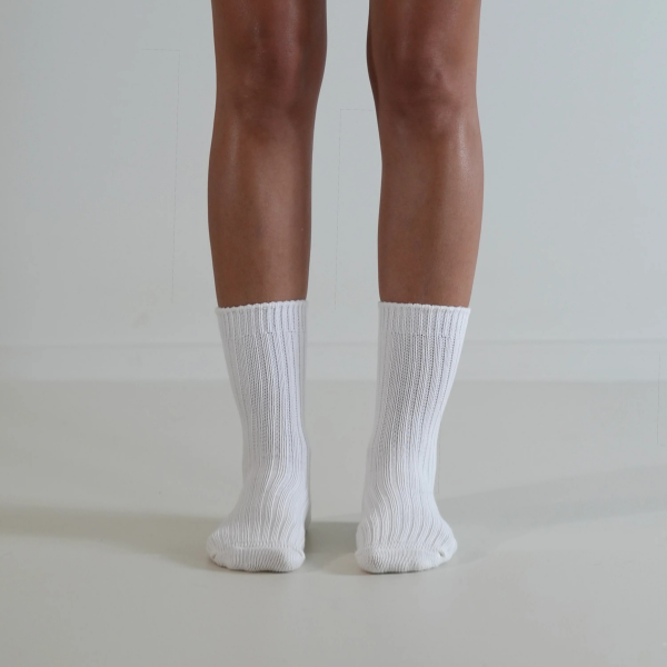 White socks on a person’s feet, front view, on a plain background. Luxe Cotton Socks by Number Thirty One made with a soft cotton, wool, and spandex blend. Unisex & One size. Stocked at LOVINLIFE Co Byron Bay for all your gifts, candles and interior decorating needs
