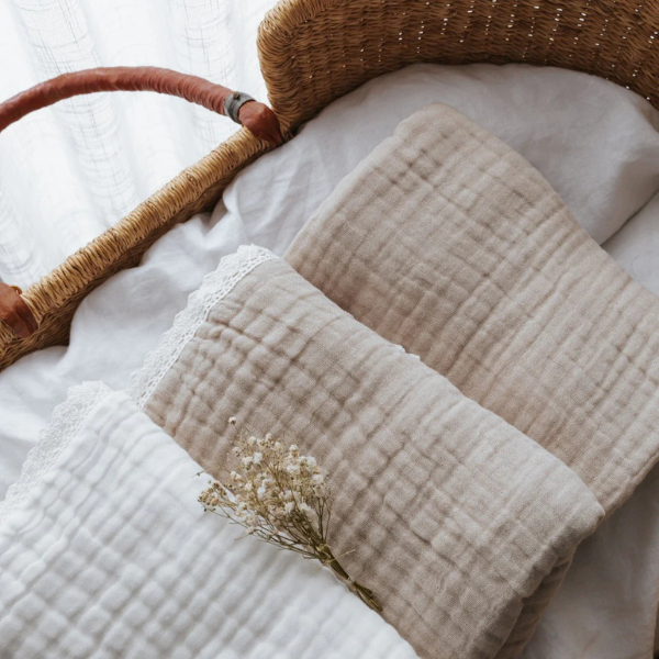 flat lay of 3 organic muslin cotton baby blankets in different neutral shades folded and lying in a baby's crib. Stocked at LOVINLIFE Co Byron Bay for all your gifts, candles and interior decorating needs