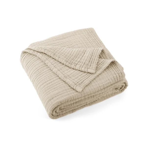 Folded organic muslin cotton baby blanket in a sand colour on a white background. Stocked at LOVINLIFE Co Byron Bay for all your gifts, candles and interior decorating needs