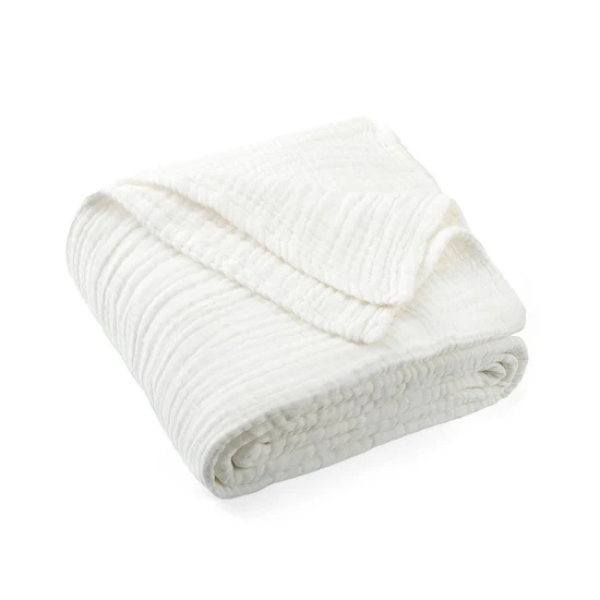 Folded organic muslin cotton baby blanket in white on a white background. Stocked at LOVINLIFE Co Byron Bay for all your gifts, candles and interior decorating needs