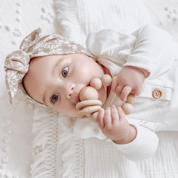 Baby holding White Silicone Ring teething toy with natural wood bead and rings - Available at LOVINLIFE Co Byron Bay