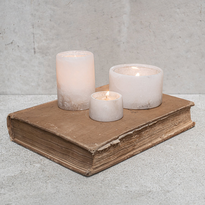 Alabaster Votive Candles by Natures Atelier - all 3 sizes pictured gathered on top of an old book - Stocked at LOVINLIFE Co Byron Bay for all your gifts, candles and interior decorating needs