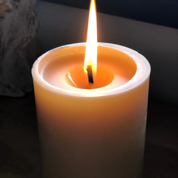 Pure beeswax pillar candle, with a pure cotton wick, burning with a dark background. Stocked at LOVINLIFE Co Byron Bay for all your gifts, candles and interior decorating needs